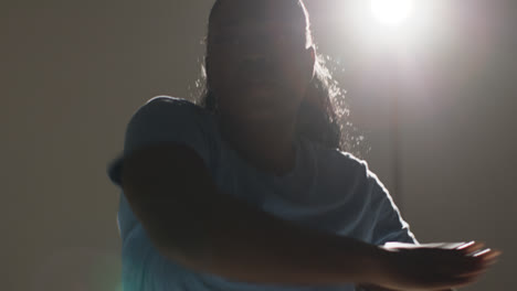 Hintergrundbeleuchtetes-Studioporträt-Mit-Kopf-Und-Schultern-Einer-Jungen-Frau,-Die-Im-Rampenlicht-Tanzt